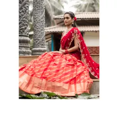 The full silhouette of the orange-red brocade lehenga, showcasing its magnificent flare and the traditional elegance of the fabric. The sequin scalloped dupatta adds a final touch of sparkle.