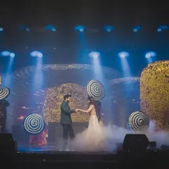 The couple's dance, set against a dream-like backdrop with theatrical props and smoke effects. We thoughtfully plan these highlights to be both visually stunning and full of genuine joy.