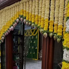 We decorated this home entrance with an arch made of yellow and white flower garlands. The design also incorporates mango leaves, which are considered auspicious in many traditional Indian ceremonies.