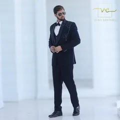 The complete look of our custom navy embroidered tuxedo, styled for a formal event. The perfect fit and unique detailing make it an ideal choice for a groom's wedding reception outfit.