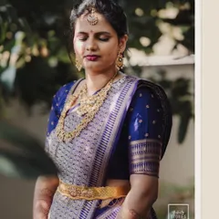 The bride in a royal blue saree, captured in a moment of quiet contemplation, showcasing her serene elegance.