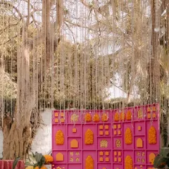 This Mehandi backdrop was all about making a statement. We designed a vibrant pink grid wall, filling it with bright orange and yellow marigold arrangements and adding a curtain of delicate hanging flowers for a touch of magic.