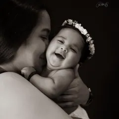 A newborn's smile is pure magic. In black and white, this intimate moment between a mother and her daughter becomes a classic, emotional portrait that they will cherish forever.