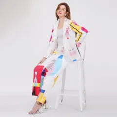 A model seated in a vibrant pantsuit, demonstrating a different pose for the same product to give customers a comprehensive view.