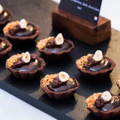 Decadent Ferrero Rocher and Belgian dark chocolate tartlets, another favourite from our catering menu. These mini desserts feature a crisp chocolate shell, a rich ganache filling, and a crunchy hazelnut topping.