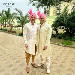 Twinning in style for a day wedding. These gentlemen are wearing our rental sherwanis, one in a classic off-white and the other an Indo-western style with a draped sash, both topped with pink safas.