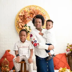 A mother with her two boys. This classic portrait showcases the bond between them in our warm, autumnal-themed studio setup.