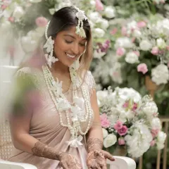 A beautiful, smiling bride adorned with floral jewelry and my intricate henna design. A picture of pure happiness.