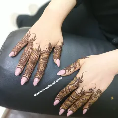 A still shot of the finished Arabic finger designs. The contrast with the light nail polish makes the henna art stand out.