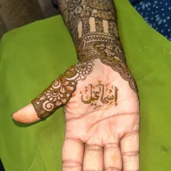 A close-up of the thumb, where the groom's name is written in a delicate and elegant script.