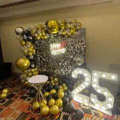 A close-up of the 25th-anniversary decor, showing the details of the balloon arrangement and sequin wall.