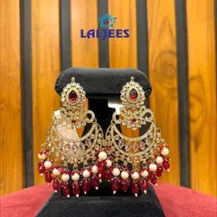 A pair of beautiful chandbali earrings with red stones and pearl drops, perfect for a traditional look.