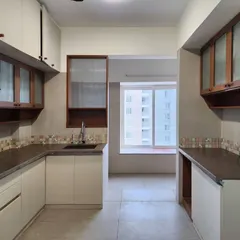This kitchen design combines off-white lower cabinets with wood-framed upper cabinets. A mosaic tile backsplash adds a touch of color and texture, creating a clean and contemporary look.