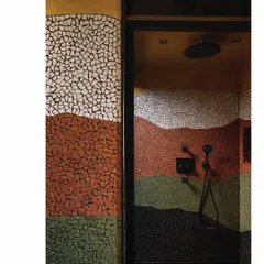 In this master bathroom, the walls themselves become a Van Gogh-inspired artwork. Colorful china mosaic is hand-laid in swirling patterns, transforming the shower into a canvas. The earthy tones and a custom Jaisalmer stone basin complete this artistic and functional space.