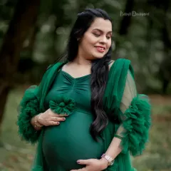Glowing with love in a gorgeous emerald green gown. This outdoor portrait captures the serene beauty and magic of the motherhood journey.
