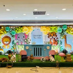 A cute cartoon jungle animal theme for a "Two Wild" birthday party, with a custom jeep-shaped table and friendly character cutouts.
