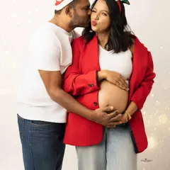 A playful and romantic Christmas couple's portrait. A sweet kiss on the cheek and festive headbands make this a perfect holiday memory.
