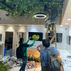 Every detail matters. Our horticulturist is seen here guiding the placement of hanging plants, ensuring the final arrangement is balanced and beautiful from every angle.