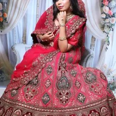 This full-length shot showcases the magnificent red velvet lehenga with its detailed embroidery. The makeup and styling are designed to be grand and impactful.
