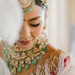 A close-up of this regal bridal look, focusing on the flawless, radiant base and softly defined eyes. The makeup is designed to enhance, not mask, creating a glow that feels like it comes from within.