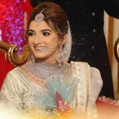 A radiant smile from the bride. Her makeup is soft and natural, with a focus on glowing skin and defined eyes that complement her diamond and pink stone jewelry.