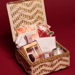 This luxury Christmas hamper for her comes in a beautiful woven basket with gold accents. It's filled with skincare, a personalized glass, a candle, and other pampering essentials.
