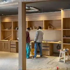 Our team is captured on-site during the installation of custom wooden shelving and workstations. This image highlights the hands-on process and attention to detail that goes into the carpentry and fit-out stages of our commercial projects.