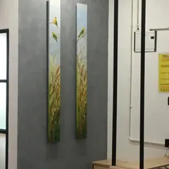 Another angle of the custom canvas art in the office space. The paintings add a natural, calming element to the professional environment, turning a structural element into a piece of art.