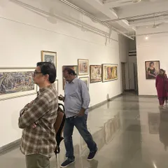 The gallery during the Vidya Bhushan show, with visitors moving through the space. The polished floors reflect the art, adding another layer to the viewing experience.