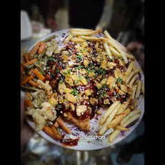 Crackling Chicken, a unique starter served with sautéed vegetables and french fries. The chicken is coated and fried to be extra crispy, then topped with cornflakes for added crunch.