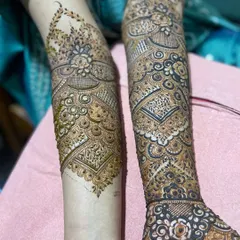 A view of two different but complementary bridal designs on both arms. One arm features heavy, traditional work while the other has a slightly more open pattern, showing how we can customize each side.