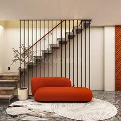 A minimalist design for a staircase landing, demonstrating that even transitional spaces can be beautiful. A vibrant orange chaise lounge provides a pop of color against the grey marble floor and wood-paneled wall. The vertical slat railing adds a sense of lightness and modernity to the staircase.