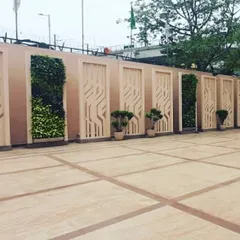 For this project, we integrated vertical garden panels with custom-designed decorative screens. This approach breaks up a long boundary wall, adding texture, depth, and pockets of vibrant, air-purifying greenery to a large paved area.
