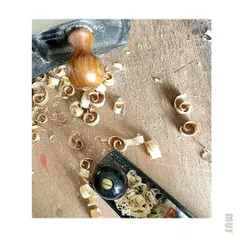 The beautiful curls of wood shavings, known as "spills," created by a sharp hand plane. This is one of the most satisfying sights in woodworking.