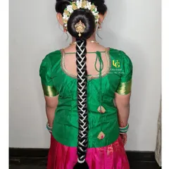 A traditional South Indian hairstyle for my young client, Poorvi. This features a neat bun covered in fresh flowers (gajra) and a long, decorated braid, making her look like a little princess.