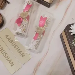 Elegance in a scroll. For the 'Aabushan' event, we created these unique scroll invitations, sealed with a wax stamp and presented in a clear box for a touch of classic luxury.