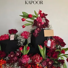 A bold and dramatic arrangement created for the wonderful Neetu Singh Kapoor. This piece uses a rich palette of deep reds, including tulips, orchids, and roses, contrasted against shimmering black gift wrapping for a truly showstopping effect.