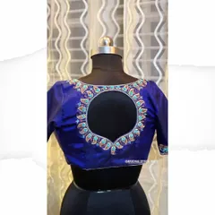 A royal blue silk blouse featuring a circular back opening. The border is meticulously handcrafted with zardosi and paisley motifs, showcasing fine craftsmanship.
