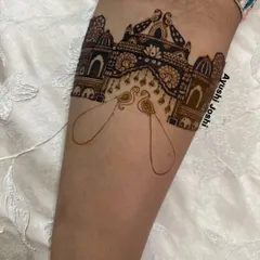 The first stage of a royal bridal mehendi, with the outline of a palace gate and peacocks. A strong foundation is key to a symmetrical and grand design.