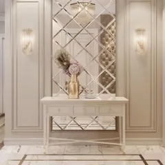 An elegant entryway featuring wall molding and a large, decorative mirror made of beveled glass pieces. The classic console table completes this sophisticated look.