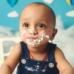 A close-up on that cake-covered smile. I love capturing the genuine, messy happiness of a baby's first encounter with a birthday cake.