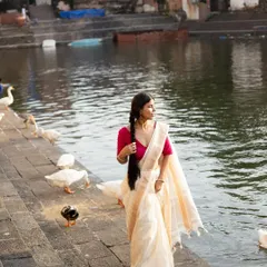 This shot captures a candid moment, interacting with the surroundings while modeling a traditional silk saree, adding a touch of authenticity to the campaign.