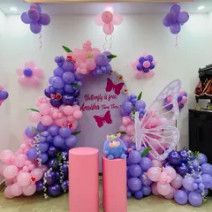 Another angle of the purple and pink butterfly party setup. This view shows the balloon flowers on the wall and the overall arrangement in a home setting.