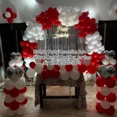 A classic red and white balloon arch decoration for a home party. This setup includes a shimmer curtain, a neon sign, and matching balloon pillars, perfect for birthdays or anniversaries.