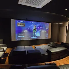 Your home theater can be a space for more than just movies. This ultra-modern setup in Nellore is perfect for immersive gaming, featuring sleek black interiors, curved custom loungers, and a high-performance 4K projector for a lag-free, larger-than-life experience.