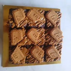 A batch of my fudgy Biscoff brownies, ready to be packed. Each square is rich, dense, and topped with a generous drizzle of Biscoff spread and a crunchy Lotus biscuit. It's one of my most requested eggless brownie flavors.