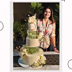 Here I am with one of my proudest creations, a grand multi-tiered wedding cake. It's always a joy to stand next to the final product after hours of planning and detailed work.