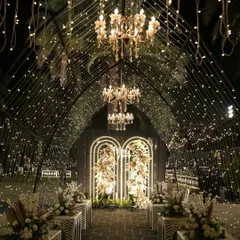 This is how I turn a sangeet night into a celestial dream. A grand tunnel entrance adorned with thousands of fairy lights and elegant chandeliers guides guests into a starry night themed celebration, promising an evening of wonder.