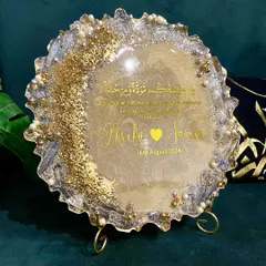 A beautiful resin engagement plaque designed to celebrate a new union. This piece features the couple's names, their special date, and a Quranic verse, all set in a shimmering gold and pearl design with a geode-style edge.