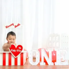 Kisses for the birthday boy. This "Kissing Booth" theme is a super cute and playful idea for a first birthday photoshoot.